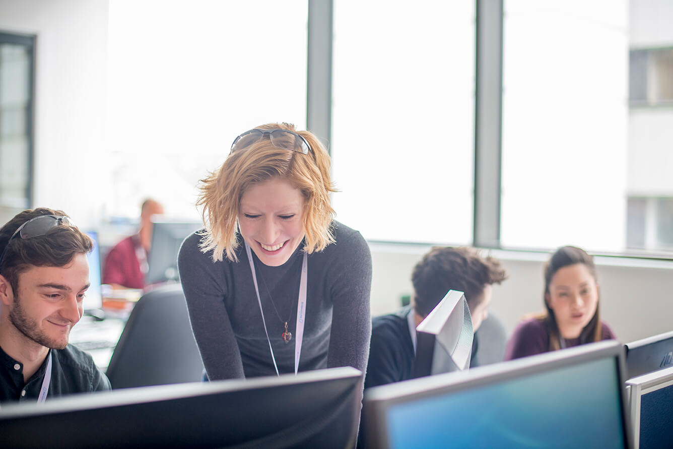Scientists working at computer workstations, representing the use of advanced software and hardware platforms for computer aided drug design.