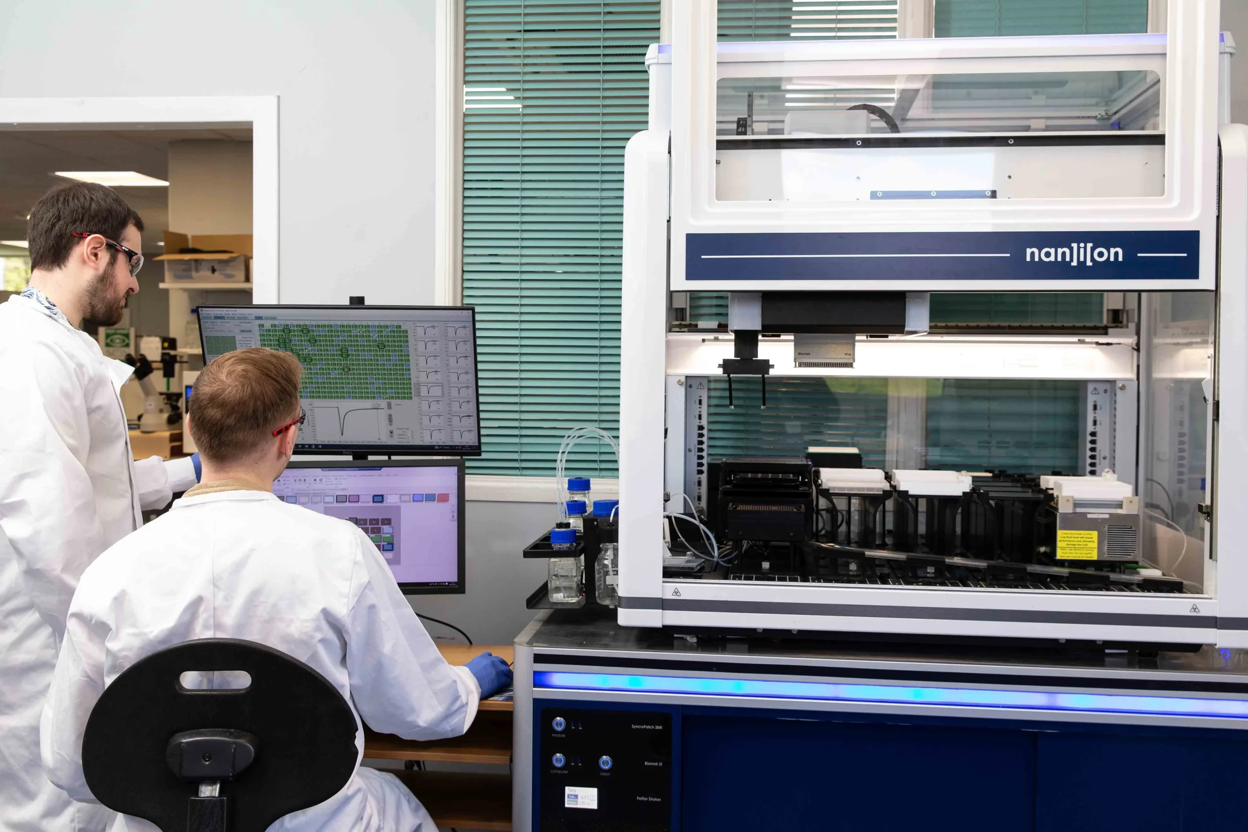 Researchers conducting electrophysiology experiments using specialized instruments to study ion channel activity and cellular responses.