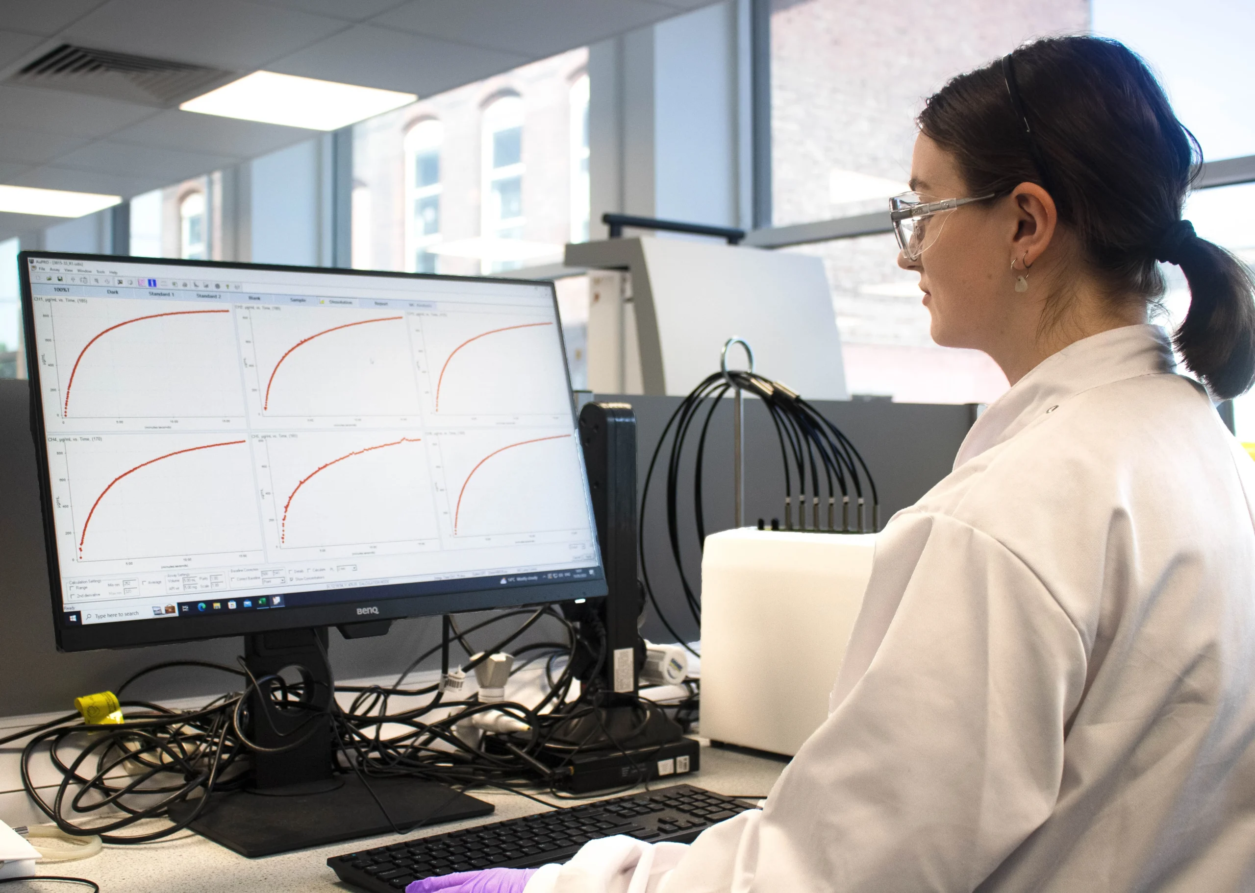 Laboratory workstation displaying formulation development data on a computer screen, illustrating scalable design for successful clinical development.