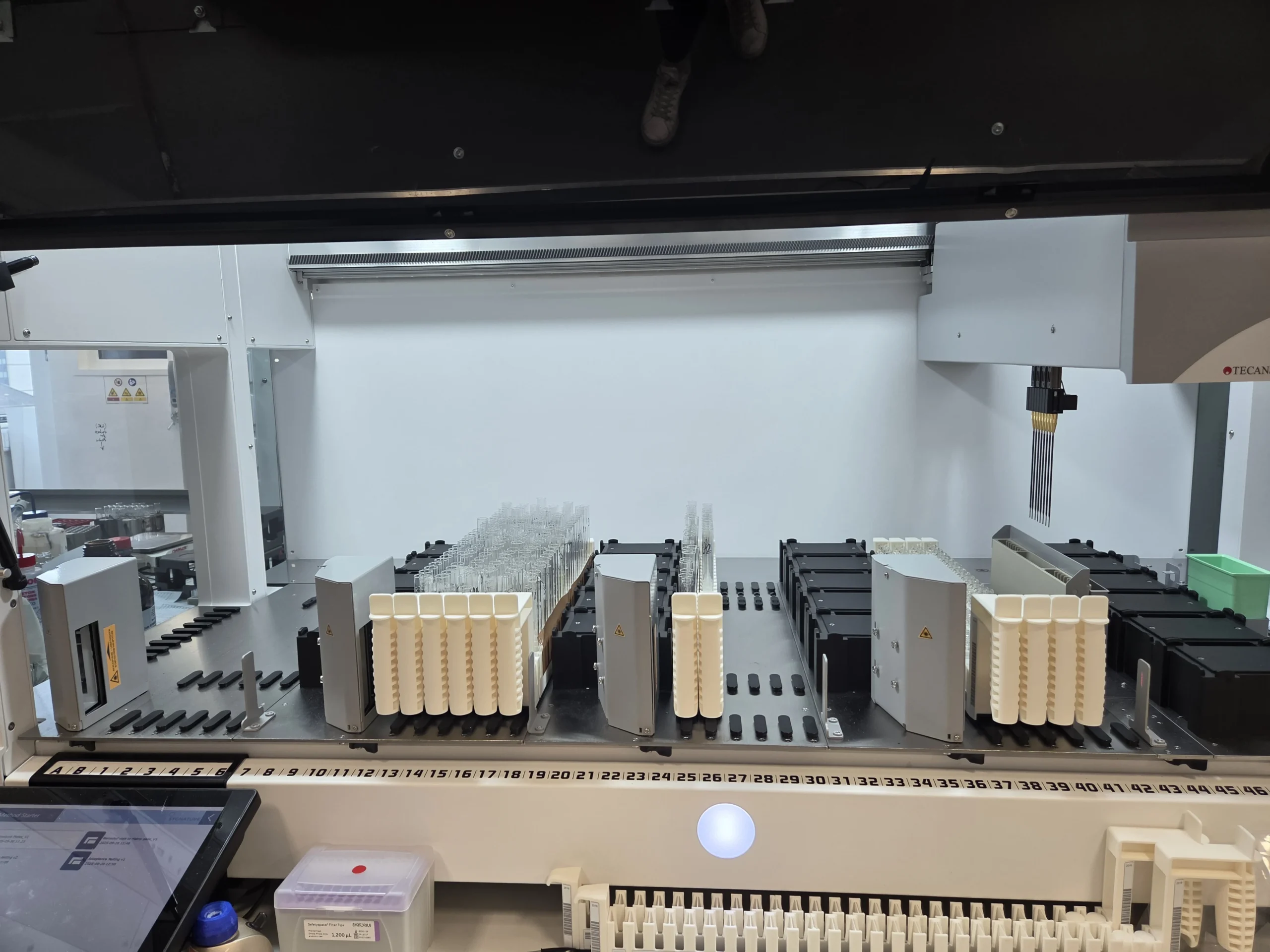 Automated high-throughput chemistry system with racks of sample tubes and robotic components, illustrating advanced automation for rapid molecule synthesis and purification.
