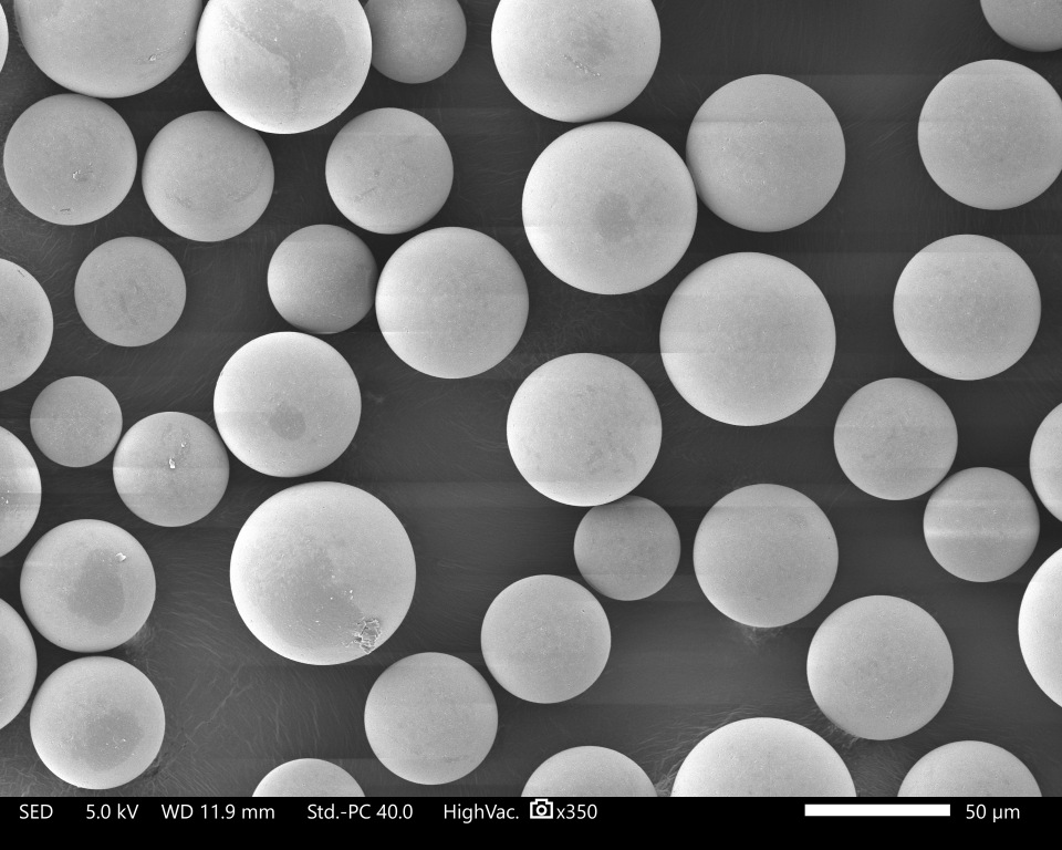 Image agrandie de billes sphériques disposées en rangées uniformes, illustrant les technologies de formulation précliniques pour une administration et une performance optimisées des médicaments.
