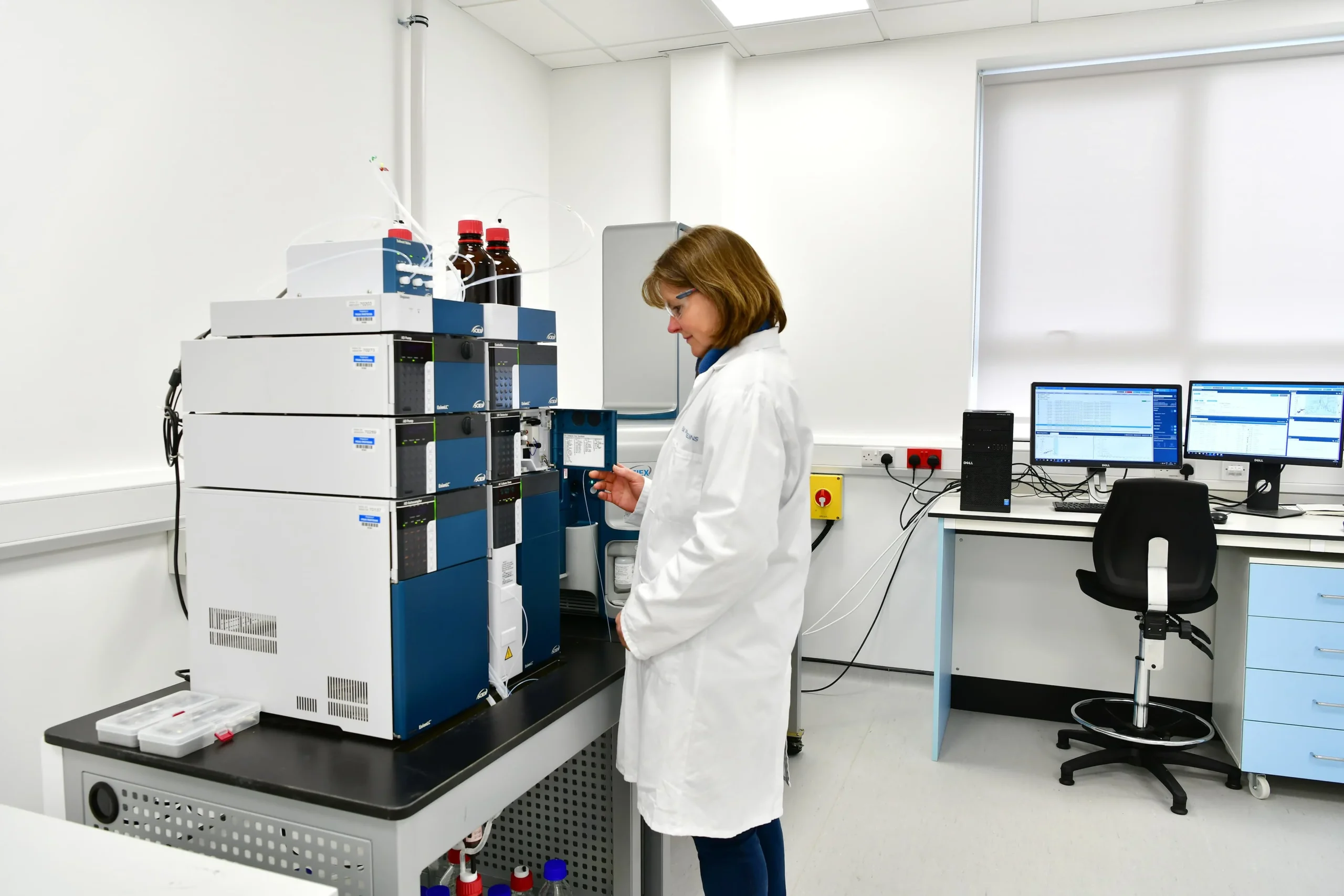 Laboratory setup with advanced biophysical instrumentation for protein characterization, including mass spectrometry, NMR, and dispersion analysis to assess identity, quality, and stability