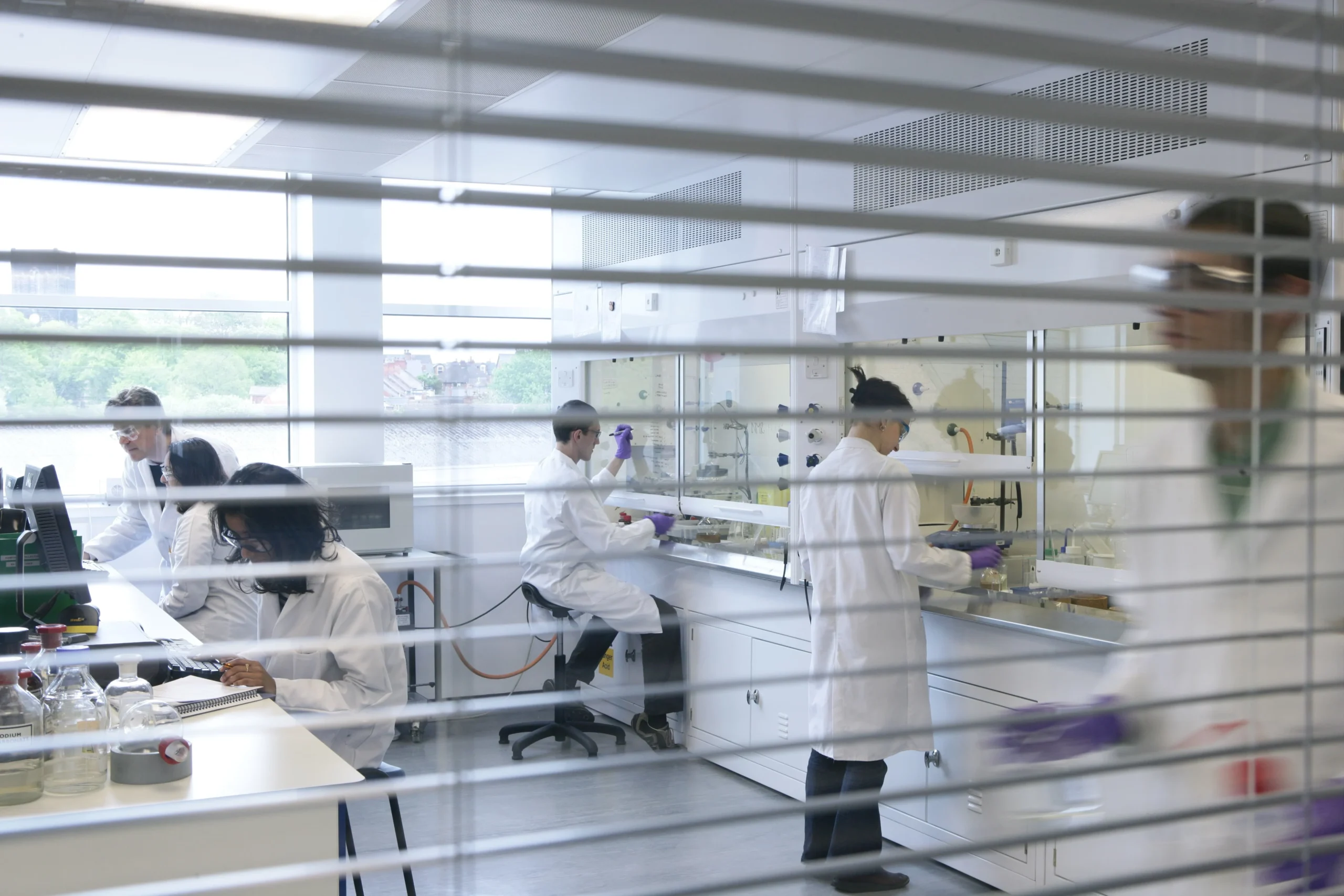Modern laboratory environment with scientists working collaboratively, representing integrated drug discovery solutions.