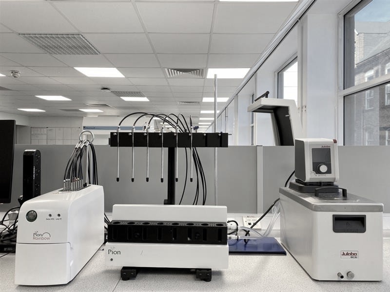 Laboratory instruments arranged on a benchtop, including automated analysis systems and precision equipment, representing solid form analysis for evaluating crystalline properties and formulation strategies in drug development.