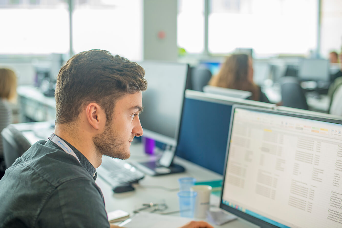 data analysis on a computer screen in a laboratory setting, supporting target identification and validation for drug discovery.